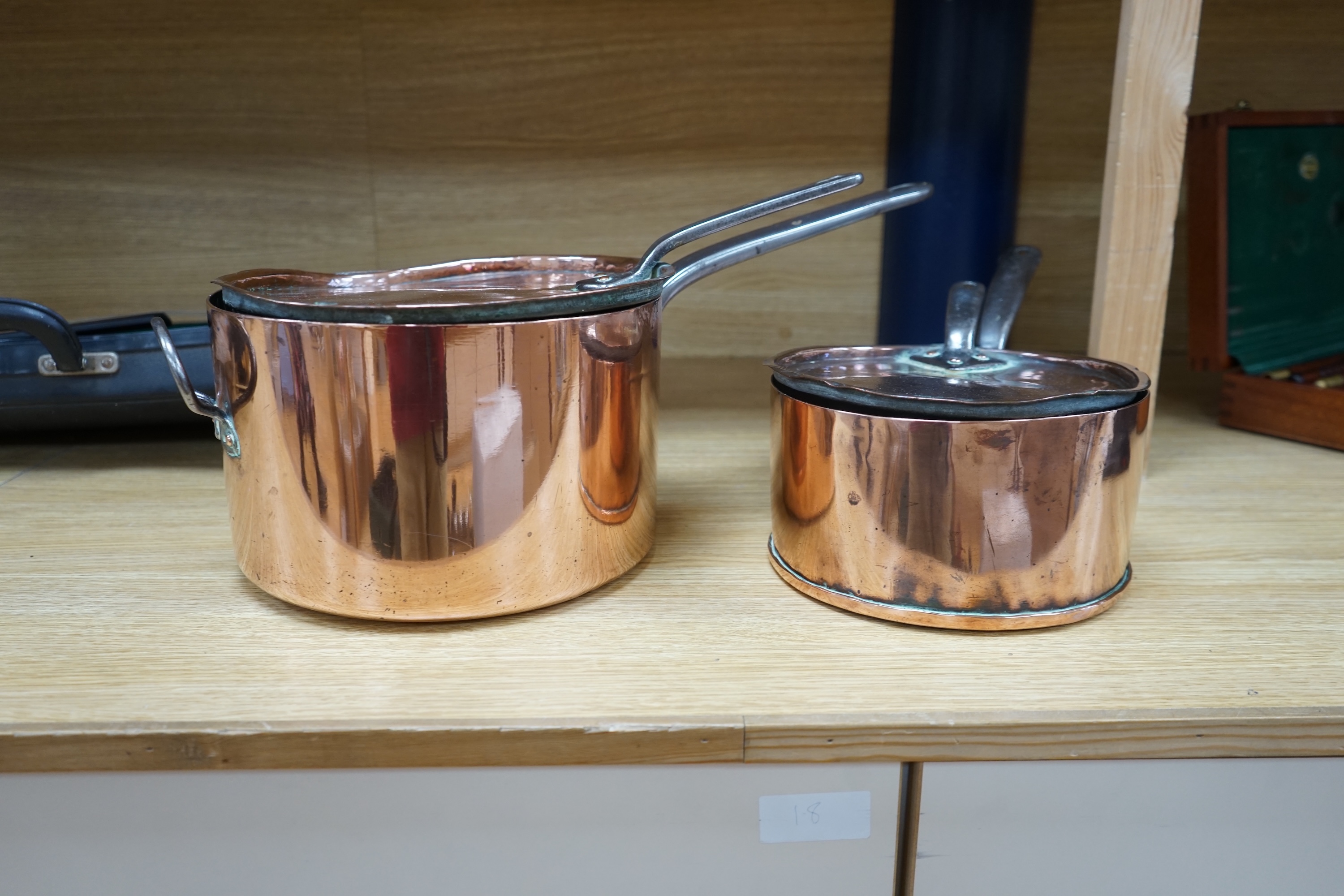 Two 19th century graduated copper and wrought iron saucepans and covers. Condition - fair to good